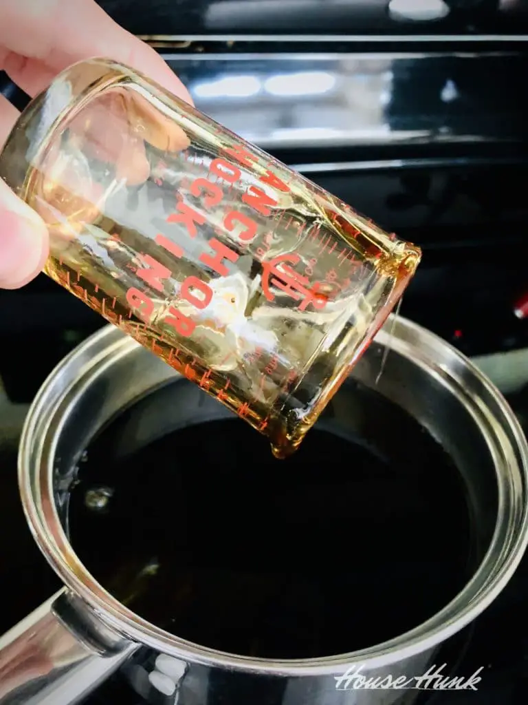 honey pouring in a pot from a measuring cup