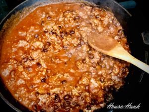 ground beef, black beans, and enchilada sauce cooking in a pan
