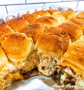 A closeup image of a tray of the best lasagna sliders made with King's Hawaiian Sweet Rolls.