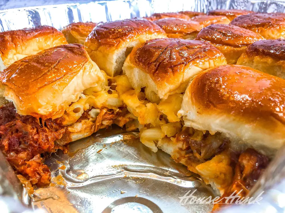 A closeup shot of a tray of the best macaroni and cheese topped pulled pork sliders