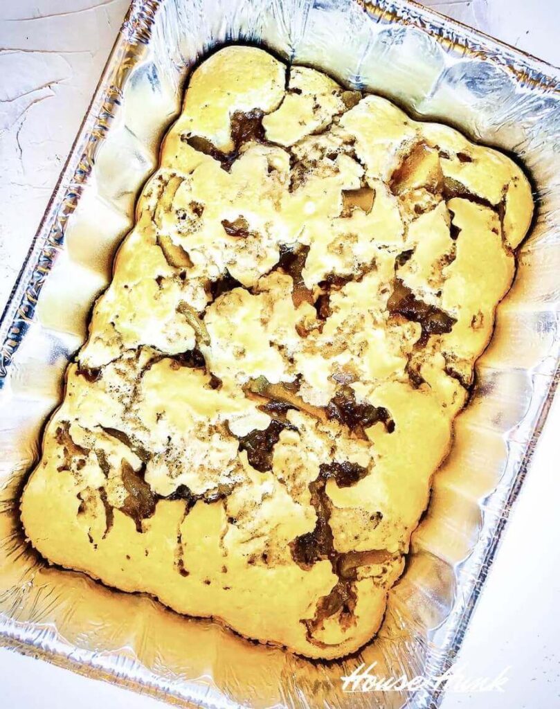 A foil tray of a sheet pan pancake with on a white countertop.