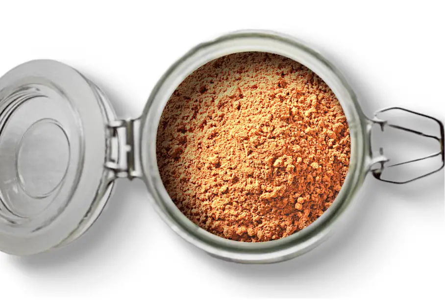 A jar of cocoa powder on a white background. The jar is a glass jar with a metal lid and a metal clasp. The lid is open and the jar is filled with light brown cocoa powder.