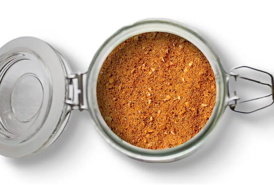 A photo of an open jar of homemade taco seasoning on a white background.