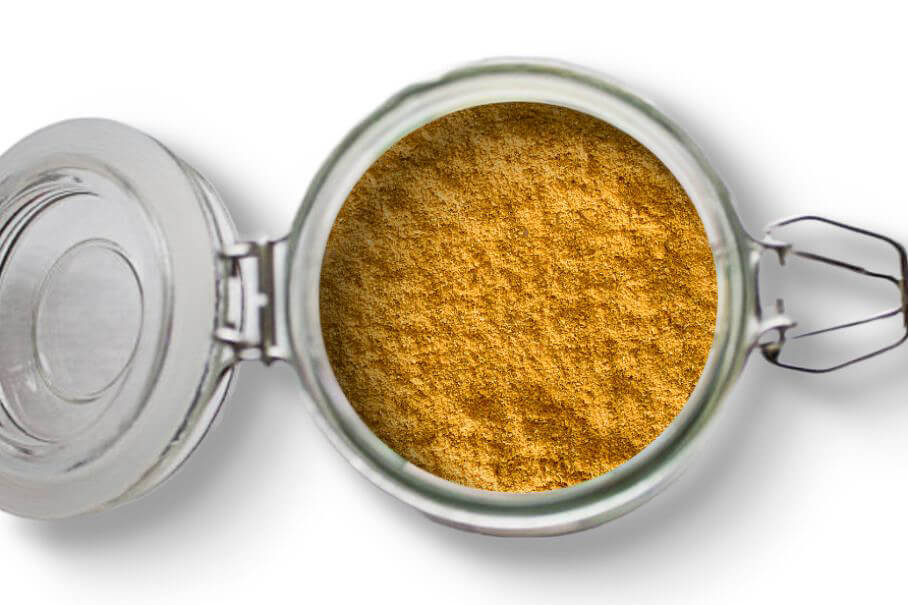 A photo of an open jar of homemade curry powder on a white background.