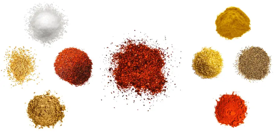 A photorealistic image of ingredients for Homemade Korean BBQ Rub consisting of nine piles of different spices and herbs on a white background.