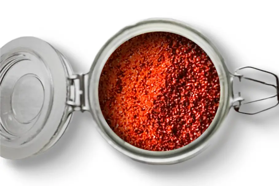 A photo of an open jar of homemade Nashville hot chicken seasoning on a white background.