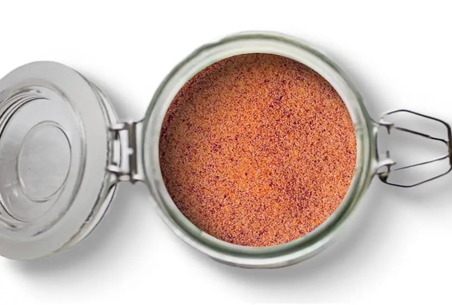 A photo of an open jar of homemade sweet cherry meat rub on a white background.