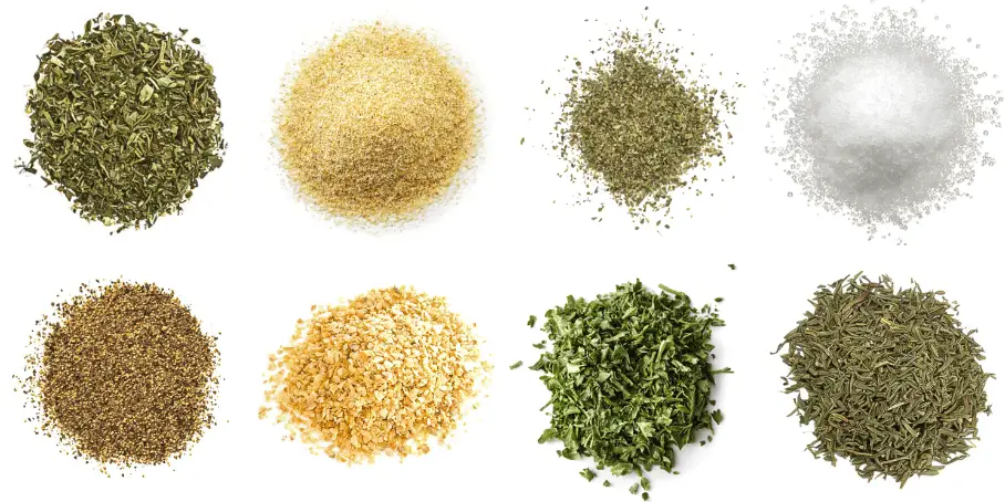 A photorealistic image of ingredients for Homemade Mediterranean Spice Blend consisting of eight piles of different spices and herbs on a white background.
