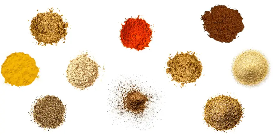 A photorealistic image of ingredients for Homemade Shawarma Spice Blend consisting of ten piles of different spices and herbs on a white background.