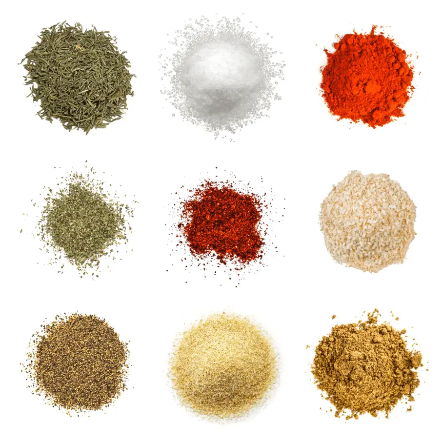 A photorealistic image of ingredients for Homemade Spanish Rice Seasoning consisting of nine piles of different spices and herbs on a white background.