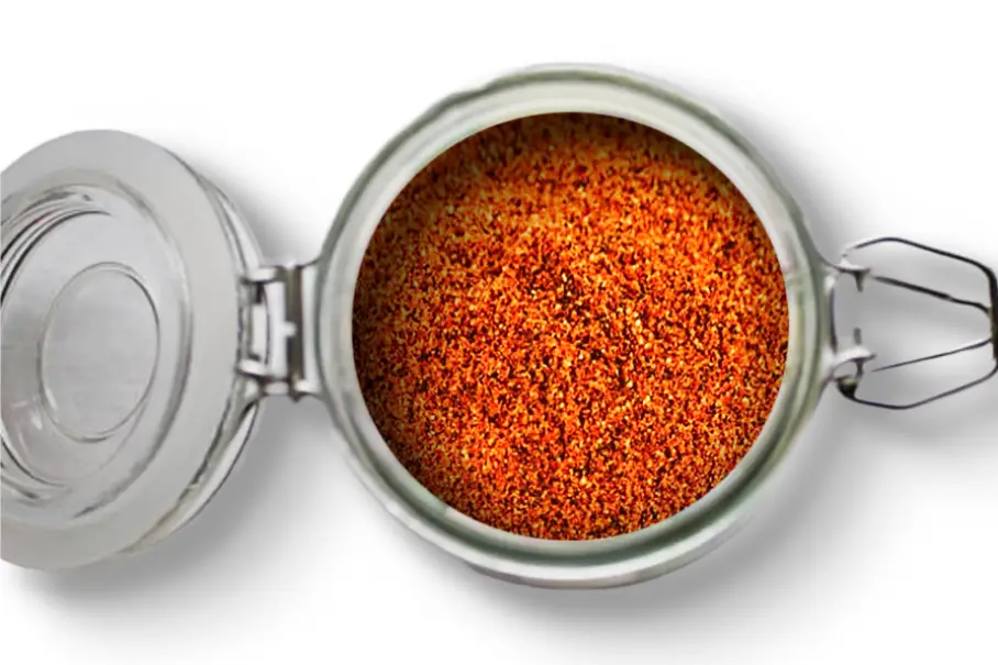 A photo of an open jar of homemade Old Bay Seasoning blend on a white background.