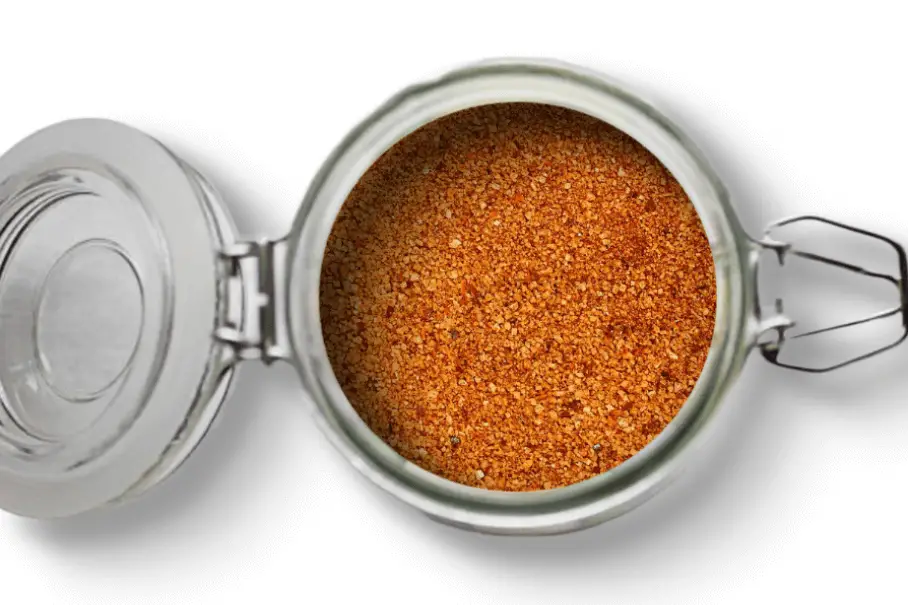A photo of an open jar of homemade crab and shrimp boil spice blend on a white background.