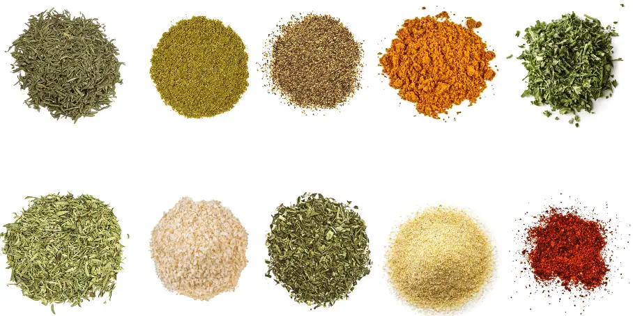 A photorealistic image of ingredients for Homemade California Spice Blend consisting of ten piles of different spices and herbs on a white background.