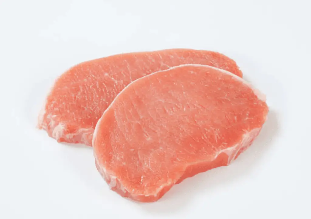 A photo realistic image of two raw pork chops on a white background.