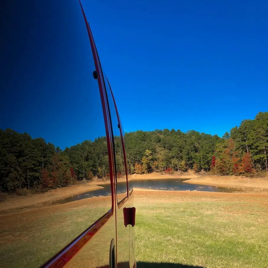 Reflection of Lake Greeson's shoreline in the window of a van at Kirby Landing Campground