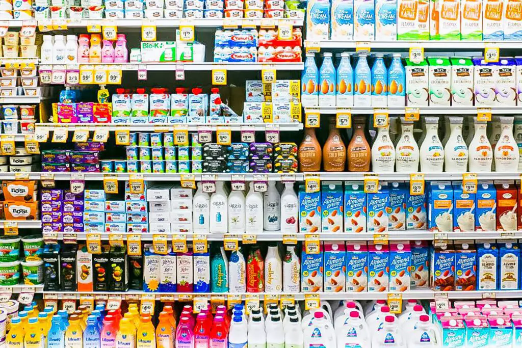 A photo of a supermarket shelf with various dairy products and brands.