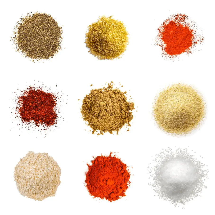 A photorealistic image of ingredients for Homemade Beef Rub consisting of nine piles of different spices and herbs on a white background.