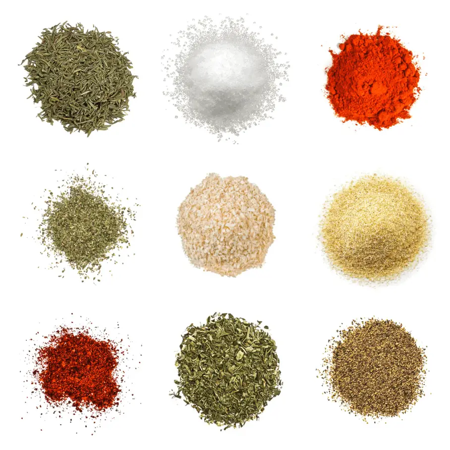 A photorealistic image of ingredients for Homemade Southern Fried Chicken Seasoning consisting of nine piles of different spices and herbs on a white background.