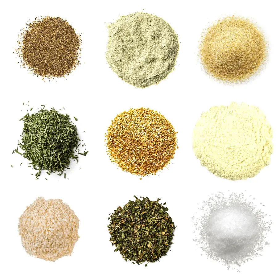 A photorealistic image of ingredients for Homemade Tzatziki Sauce Seasoning consisting of nine piles of different spices and herbs on a white background.