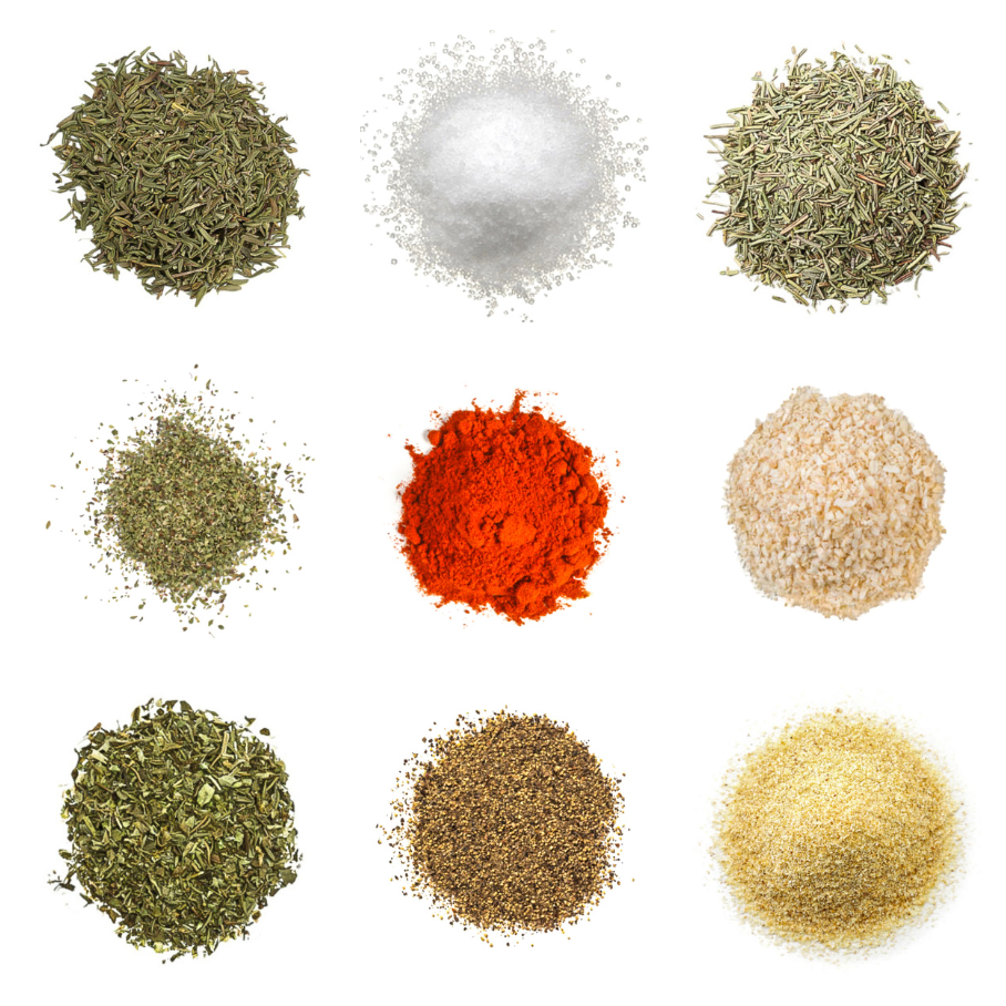 A photorealistic image of ingredients for Homemade Cape Cod Seasoning consisting of nine piles of different spices and herbs on a white background.