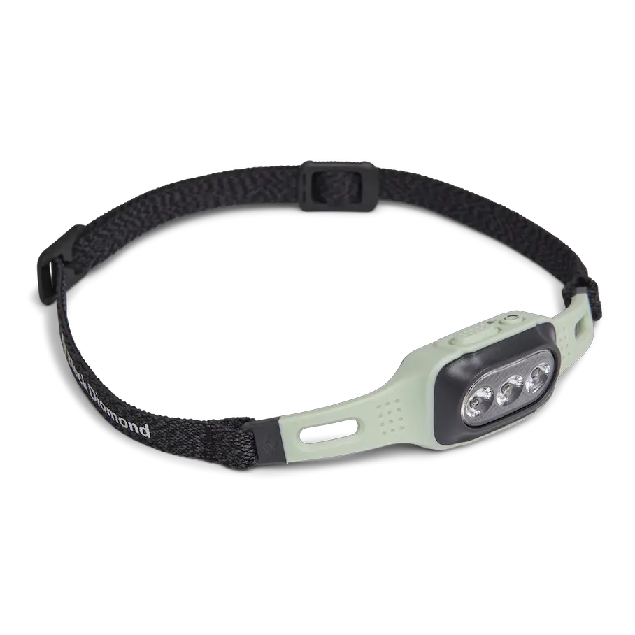 A headlamp with a white and black body and a black strap. The headlamp has three LED lights on the front and a button on the side. The headlamp has a “black diamond” logo on the strap.