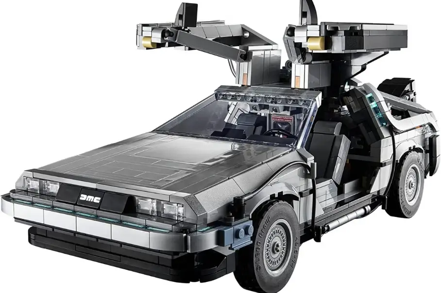 A Lego model of the DeLorean car from the movie “Back to the Future” is shown on a white background. The car is silver with black accents and has gull-wing doors and a flux capacitor. The car is made of Lego bricks and has a detailed interior.